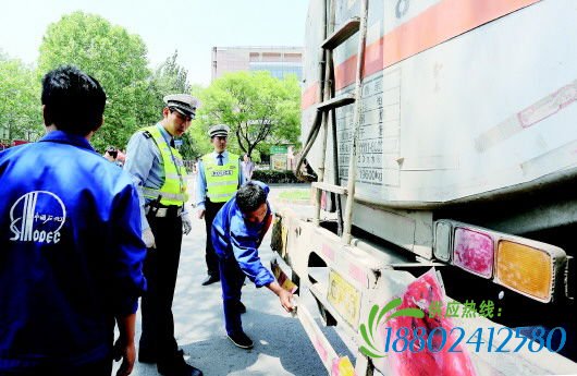 交警在向油罐车司机调查了解情况。