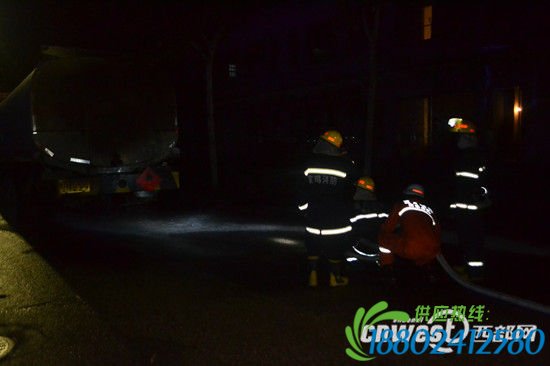 消防官兵用水枪对路面的柴油进行冲刷稀释