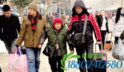 昨日，两名男子搀扶着一位老人走往郑州火车站进站口