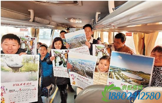 绍兴摄影家协会志愿服务队正在给回乡的旅客赠送“把绍兴带回家”的挂历。
