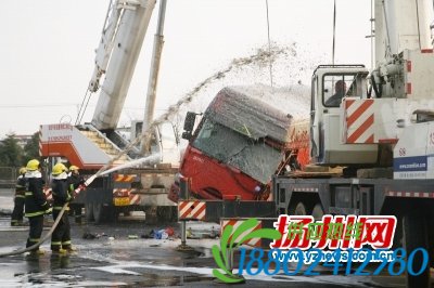 消防员向钢丝吊绳上喷泡沫防止起火。