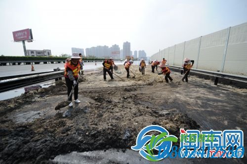 高速路政运来沙子，铺在沥青上，等沙子与沥青结成一团，再用铲子将沥青铲除