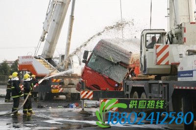 消防员向钢丝吊绳上喷泡沫防止起火。