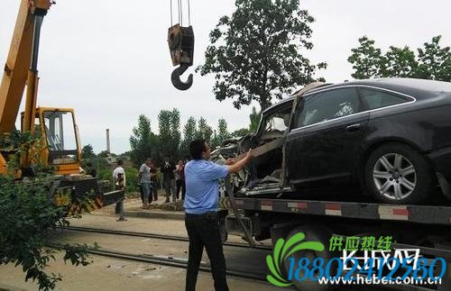 警方将事故轿车吊起拖走。