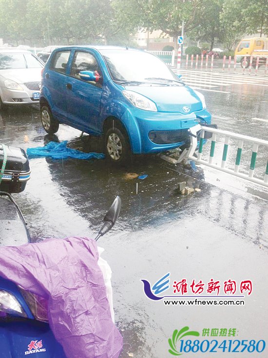 潍坊一女司机粗心大意 汽车“骑”上护栏