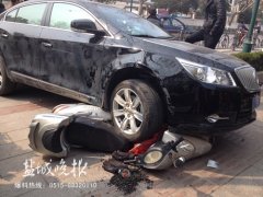 轿车撞上护栏压倒电动车车主