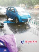 潍坊一女司机粗心大意 汽车“骑”上护栏